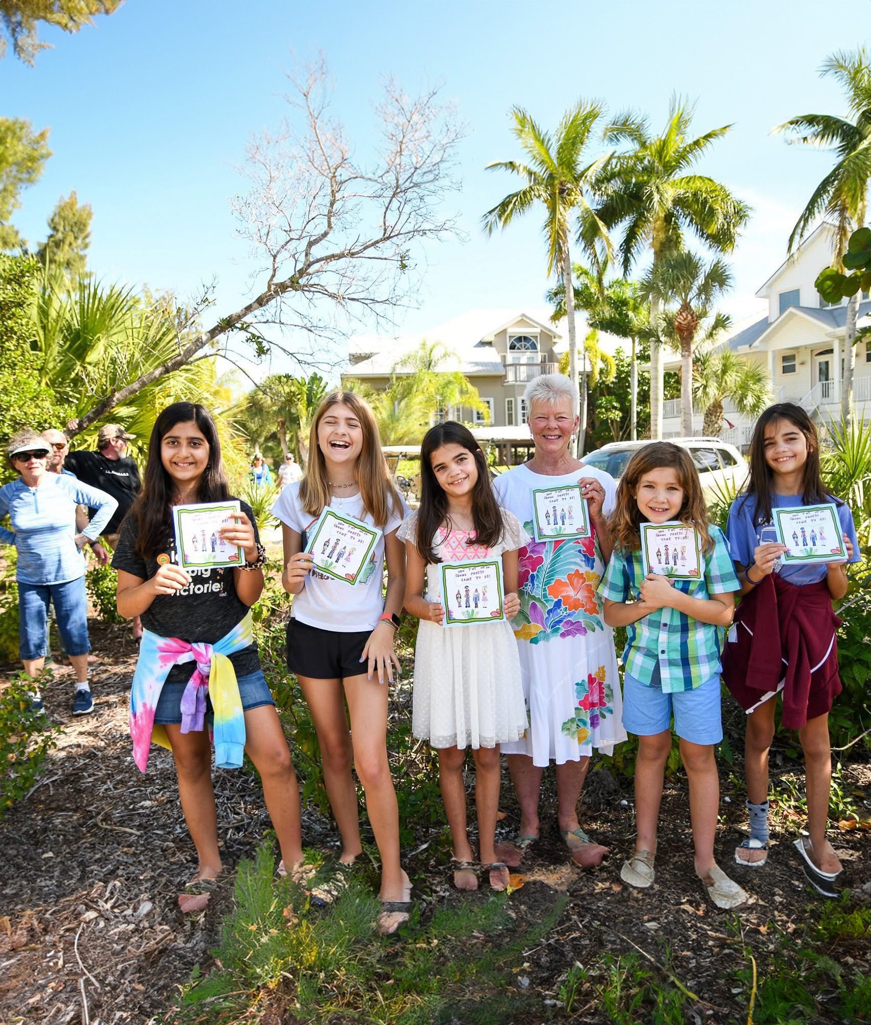 Volunteer Judy Galloway with children writing a book.